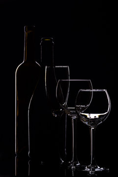 Wine glasses with wine bottle on a black background, minimalism, silhouette
