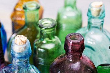 Coloured glass bottles on a rustic background