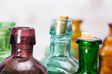 Coloured glass bottles on a rustic background