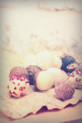 Selection of delicious chocolates on a rustic background