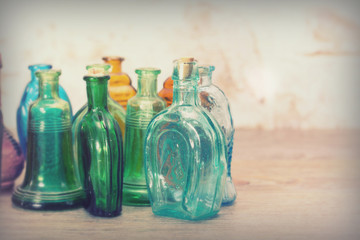 Coloured glass bottles on a rustic background