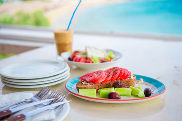 Traditional lunch with delicious fresh greek salad, frappe and brusketa served for lunch at outdoor cafe