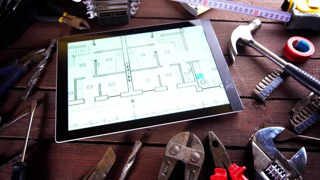 Many old rusty tools and modern tablet on desk
