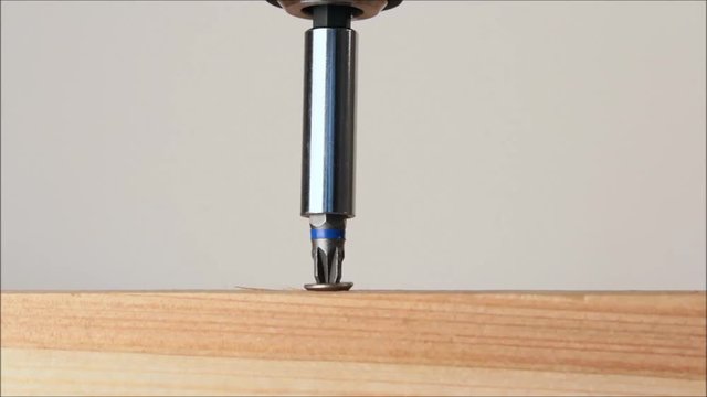 Screw being screwed into a piece of wood
