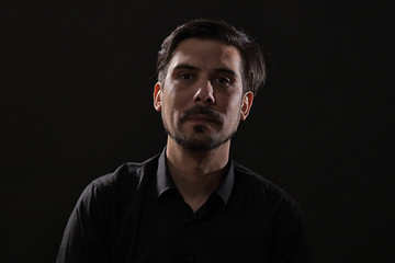 Portrait of adult man on black background.