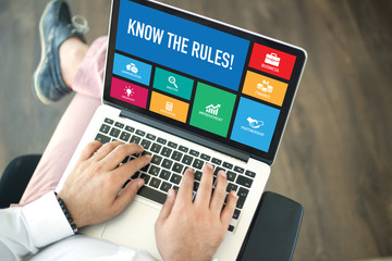 People using laptop in an office and KNOW THE RULES! concept on screen