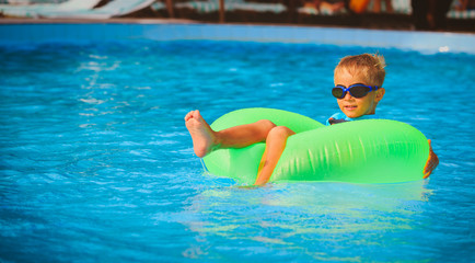 little boy in life ring fun at the swimming pool