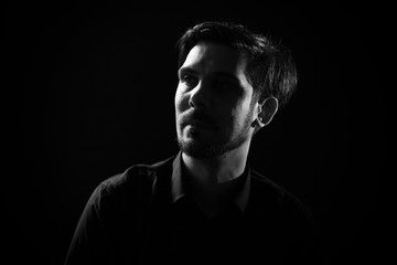 Fototapeta na wymiar Portrait of adult man on black background. Black and white image.