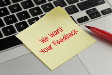 We Want Your Feedback sticky note pasted on the keyboard