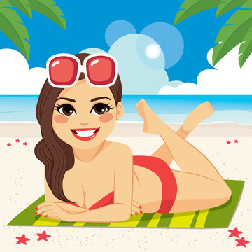 Beautiful brunette woman lying on beach towel