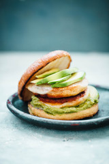 Green avocado chicken patties hamburger. Avocado dip with chicken grill patties in bread bun. 