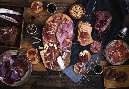 Tapas selection. A cutting board with charcuterie. Spanish cured meat, jamon, lomo, chorizo, salchichon. Charcuterie concept. Top view.