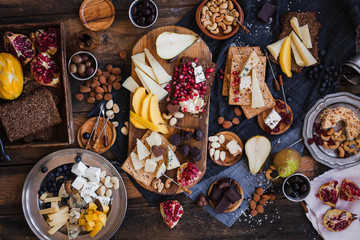 Appetizers table. Cheese variety board with tropical fruits, nuts, and wine.