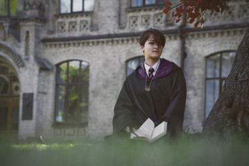 Girl wizard outdoor, reading book. Cosplay