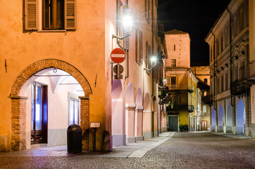 Fototapeta na wymiar Piazza Risorgimento and the medieval colonnade of via Cavour, one of the main street of the town center of Alba (Piedmont, Italy) at night