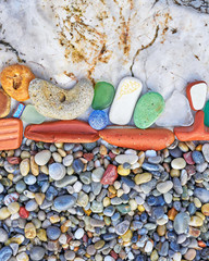 various colorful remains polished by the sea on pebble and white rock beach