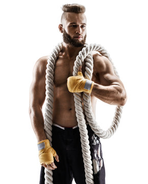Attractive muscular man with heavy ropes on his shoulders. Photo of young man in sportswear isolated on white background. Strength and motivation.