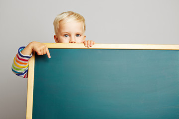 Kind zeigt auf leere Tafel