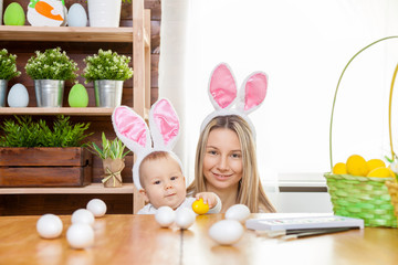 Happy mother and her cute child wearing bunny ears, getting ready for Easter