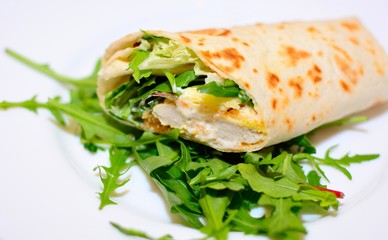 Tortilla wrap with chicken nuggets, fresh vegetable and salad.