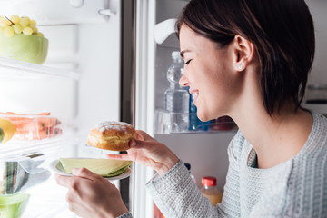 Woman taking a pastry out of the fridge