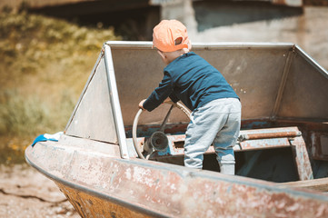 A little boy in a cap on the old boat.