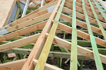 The wooden structure of the building. Wooden frame building. Wooden roof construction. Installation of wooden beams at construction the roof truss system of the house.
