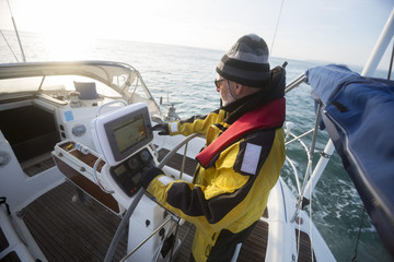 Man Operating Navigational Screen On Sail Boat In Sea
