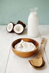 Coconut oil and milk on a light wooden background