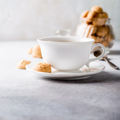 Obraz na płótnie Canvas White cup of coffee with amaretti cookies on light gray background with copy space.