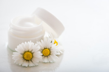 Fototapeta na wymiar Face cream with spring flowers on white background