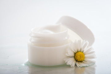 Face cream with spring flowers on white background