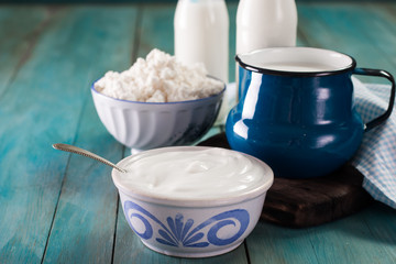 Dairy products on wooden table over blue background