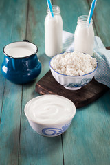 Dairy products on wooden table over blue background