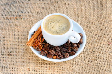 One Cup of hot coffee. A hot Cup of coffee on a saucer on the background of burlap.