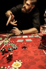 Bearded man throwing poker chips on table while playing poker