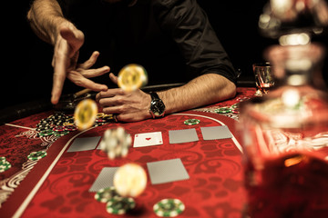 Partial view of man throwing poker chips on table while playing poker
