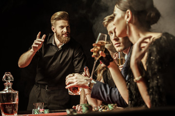 side view of men and women playing poker in casino