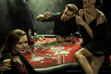 side view of group of people playing poker together in casino