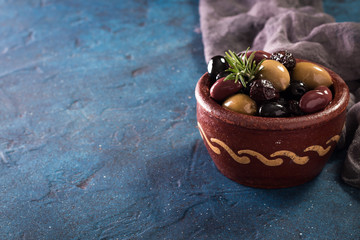 bowls with different kind of olives green olives, black olives, kalamata olives on table