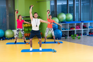 Fototapeta na wymiar Kettlebells swing exercise man and woman workout at gym