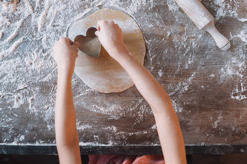 'Close-up partial view of child preparing cookies, Mothers day concept