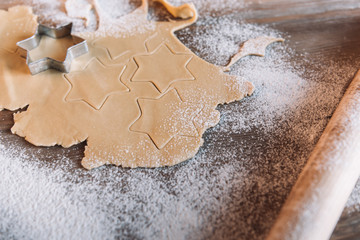 'Close-up view of unbaked cookies with cutter and rolling pin on table