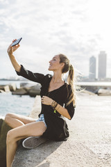 Young woman taking a selfie at the seafront