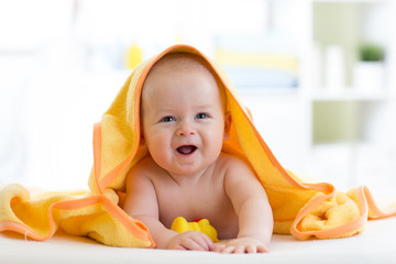 happy baby infant in towel after bathing