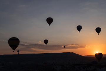Hot air balloons silhouette over spectacular Cappadocia.