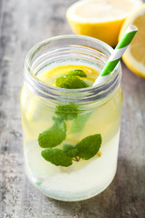 Lemonade drink in a jar glass on wooden background. Copyspace.
