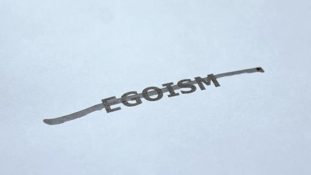 Stop Egoism. Man hand crosses out the word Egoism with black marker. No Egoism