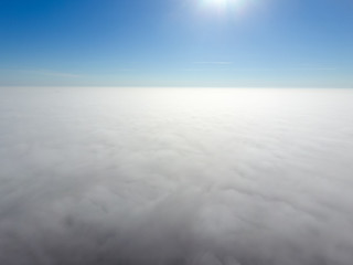 In the skies above the fog. Sunrise over the fog. Clouds near the ground