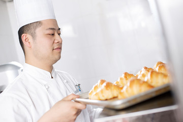 young man chelf makes bread in kitchen